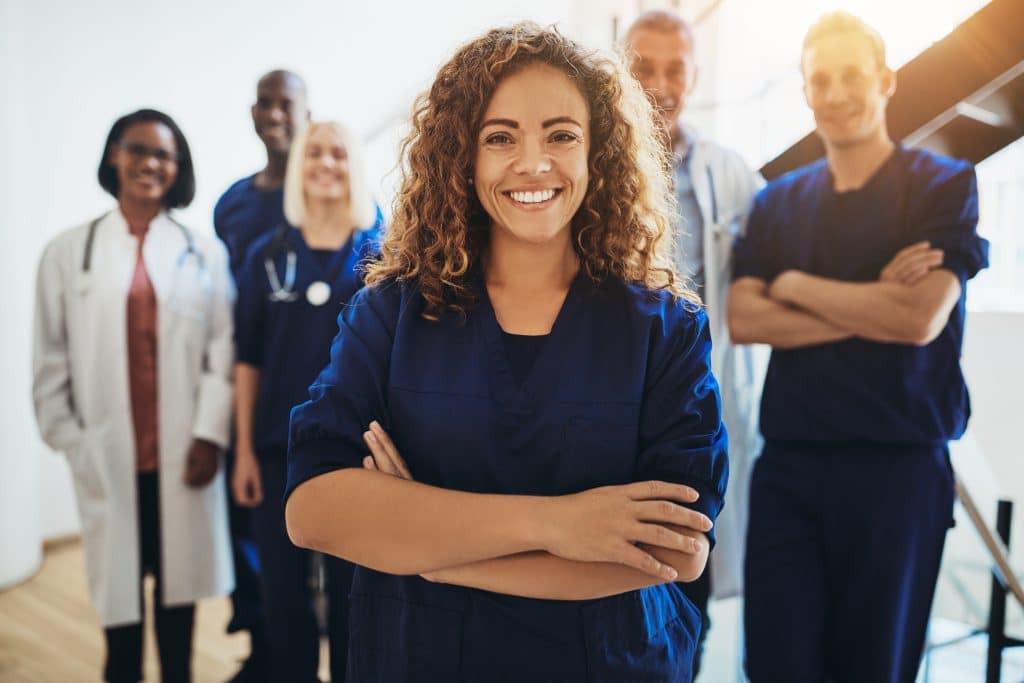 Smiling female doctor standing with medical staff in a hospital